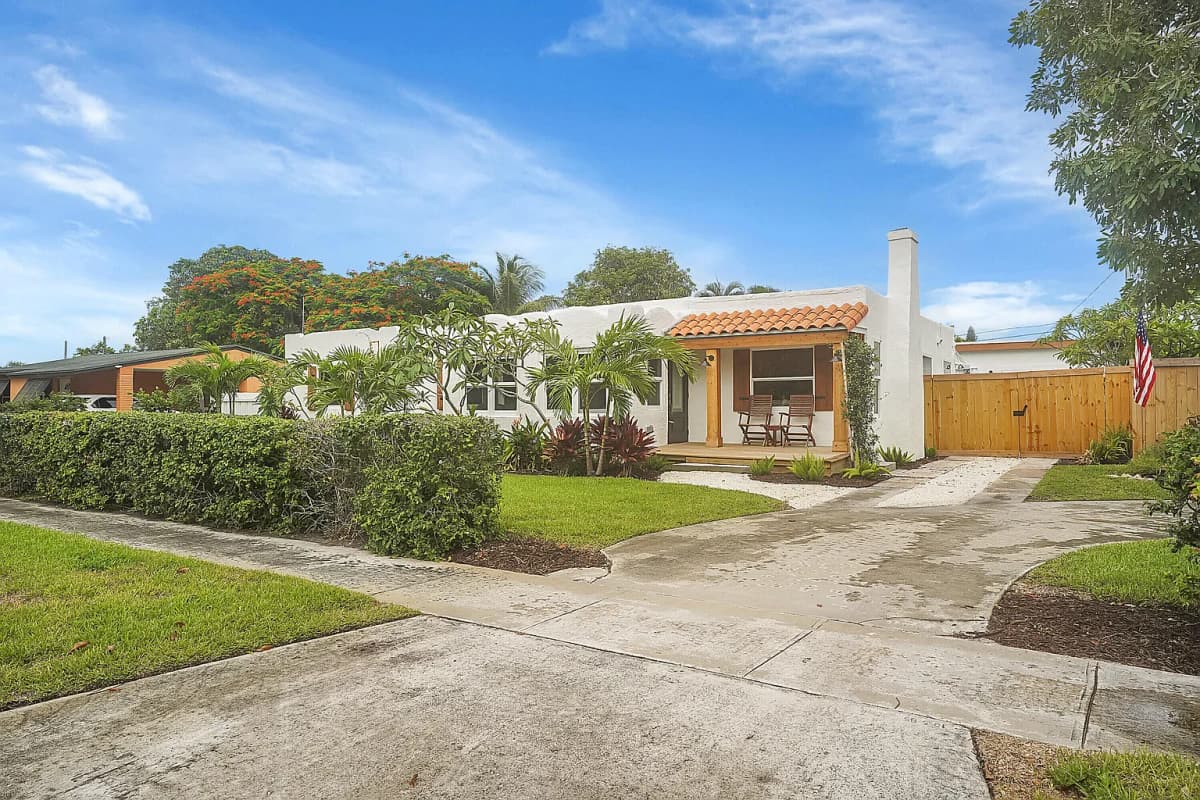 White stucco home with wood shutters and a tile roof