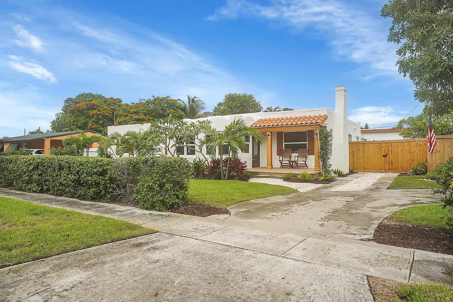 White stucco home with wood shutters and a tile roof